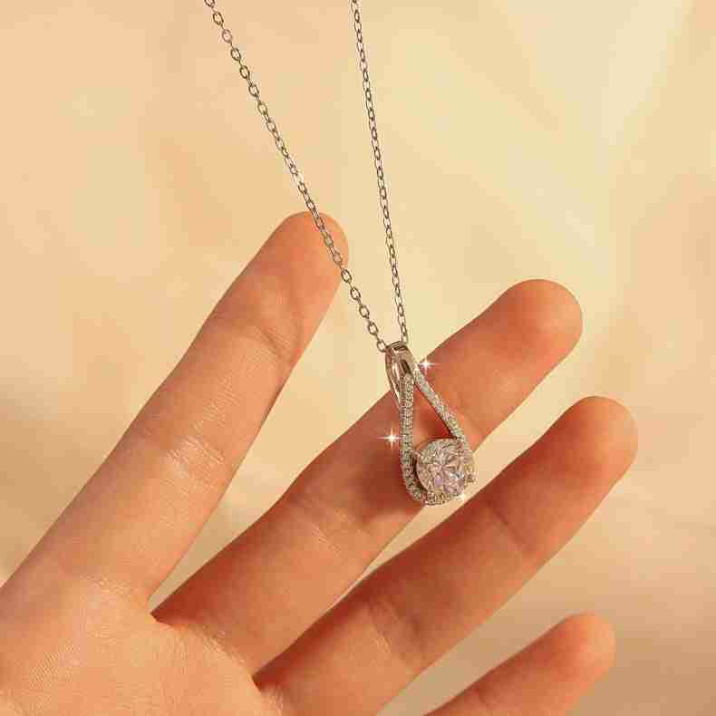 Woman wearing a silver necklace with a cubic zirconia teardrop pendant, delicate jewelry accessory for women, elegant gift idea - SKU: 1789112202074787841