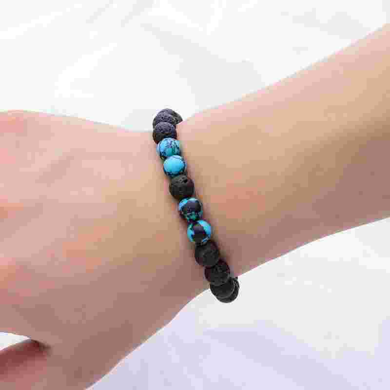Black volcanic stone and turquoise bead bracelet displayed on a white background, highlighting the contrasting colors and textures