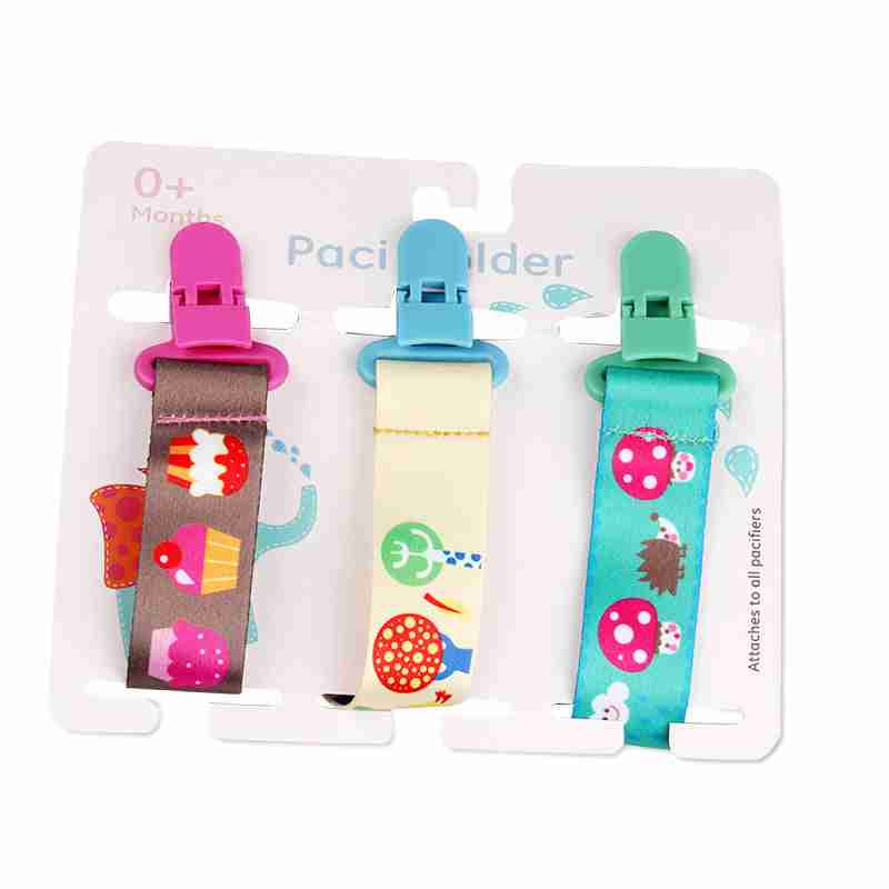 Pack of three vibrant baby pacifier clips with playful patterns including cupcakes, robots, and carrots, made of soft fabric with plastic clips.