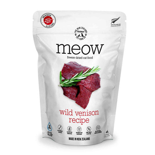 White resealable bag of freeze dried cat food with black text and red accents, featuring a picture of raw venison and green herbs, made in New Zealand
