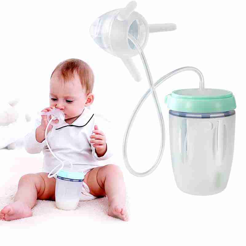 Baby using silicone sippy training cup with straw, sitting on a white surface, demonstrating toddler drinking activity